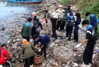 Mahasiswa pecinta alam saat membersihkan pesisir Pelabutan Timur, Desa / Kecamatan Kamal, Bangkalan. (NUR FITRIA / KLIKMADURA)