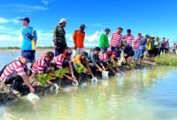Puluhan nelayan dan Perhutani KPH Madura saat menebar bibit ikan bandeng di Dusun Trakem, Desa Majungan, Kecamatan Pademawu, Rabu (29/4/2026). (MOH. IQBALUL KHAVEI MZ / KLIKMADURA)