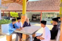 Kepala SRMP 29 Pamekasan Aisyah Minarni Mukti bersama para siswa sedang duduk santai (LAILIYATUN NURIYAH/KLIK MADURA).
