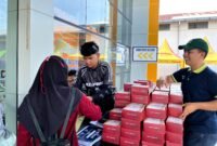 Perwakilan Azana Style Hotel Pamekasan membagikan snackbox kepada peserta lomba di KCM. (LAILIYATUN NURIYAH / KLIKMADURA)