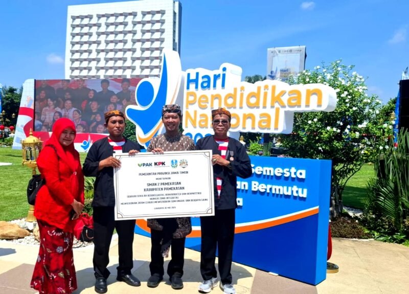 Kepala SMAN 2 Pamekasan, Moh. Arifin (kanan) menunjukkan penghargaan Lencana Jer Basuki Mawa Beya yang diserahkan Gubernur Jatim, Khofifah Indar Parawansa. (ISTIMEWA)