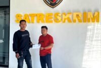 Dua Aktivis dari Forum Mahasiswa dan Masyarakat Revolusi (FORMAASI) dan Tim Pencari Fakta Nusantara menunjukkan berkas laporan di Polres Pamekasan, Jumat (8/5/2026).