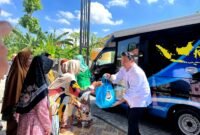 Petugas Imigrasi Pamekasan, saat memberikan sembaok kepada warga Dusun Glagga, Desa Panglegur, Kecamatan Pamekasan, Rabu (13/5/2026).