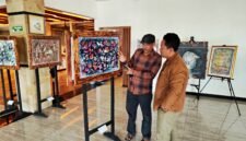 BH. Riyanto menjelaskan makna dan filosofi salah satu lukisan kepada Pemred Klik Madira, Prengki Wirananda di Hotel Odaita, Pamekasan. (ISTIMEWA)