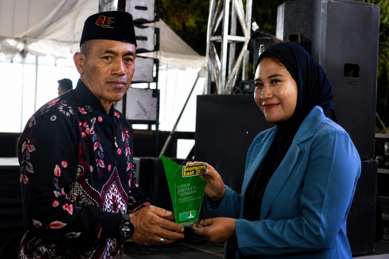 Manager Klinik Kecantikan Elysia Estetika, Sofi saat menerima tropy penghargaan. (IMDAD FAIHA ILA SABILA / KLIKMADURA)