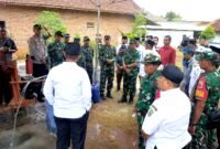 Warga dan aparat TNI menyaksikan Pembangunan sumur bor dan tandon air di Desa Panyepen, Kecamatan Jrengik. (KLIKMADURA)