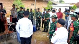 Warga dan aparat TNI menyaksikan Pembangunan sumur bor dan tandon air di Desa Panyepen, Kecamatan Jrengik. (KLIKMADURA)