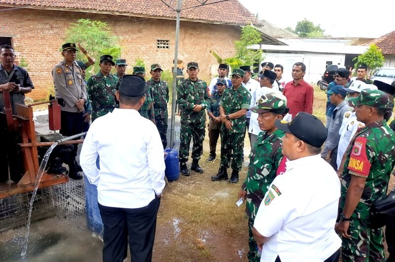 Warga dan aparat TNI menyaksikan Pembangunan sumur bor dan tandon air di Desa Panyepen, Kecamatan Jrengik. (KLIKMADURA)