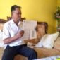Kepala Desa Banyukapah, Kecamatan Kedungdung, Kabupaten Sampang, Ruspandi menunjukkan surat penyaluran bansos. (KLIKMADURA)