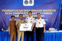 Kepala Kantor Imigrasi Kelas II Non TPI Pamekasan Ahmad Muttaqin menyerahkan cinderamata kepada kepala desa Omben usai kegiatan. (KLIKMADURA)