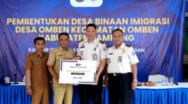 Kepala Kantor Imigrasi Kelas II Non TPI Pamekasan Ahmad Muttaqin menyerahkan cinderamata kepada kepala desa Omben usai kegiatan. (KLIKMADURA)