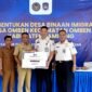 Kepala Kantor Imigrasi Kelas II Non TPI Pamekasan Ahmad Muttaqin menyerahkan cinderamata kepada kepala desa Omben usai kegiatan. (KLIKMADURA)