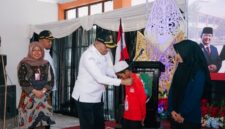 Bupati Sampang H. Slamet Junaidi saat mengalungkan tanda peserta MPLS Sekolah Rakyat Terintegerasi 1 Sampang. (KLIKMADURA)