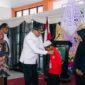 Bupati Sampang H. Slamet Junaidi saat mengalungkan tanda peserta MPLS Sekolah Rakyat Terintegerasi 1 Sampang. (KLIKMADURA)