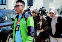 Direktur CV Dzarrin Putra Utama berinisial M (tengah) saat tiba di Polres Pamekasan setelah di jemput paksa oleh penyidik. (KLIKMADURA)