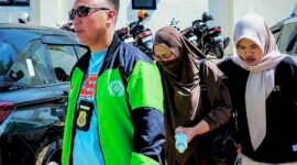 Direktur CV Dzarrin Putra Utama berinisial M (tengah) saat tiba di Polres Pamekasan setelah di jemput paksa oleh penyidik. (KLIKMADURA)