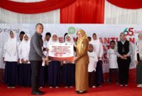 Pimpinan Bank Jatim Cabang Pamekasan, Yuda Imawan Sutanto menyerahkan bantuan secara simbolis kepada Sekretaris Disdikbud Pamekasan, Fatimatus Zahrah. (KLIKMADURA)