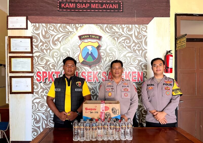 Kapolsek Sapeken Iptu Wijono Aris Sasongko, S.H., didampingi personel menunjukkan miras yang berhasil diamankan. (POLRESTA SUMENEP FOR KLIKMADURA)