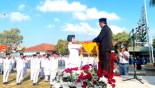 Kepala SMAN 2 Pamekasan Moh. Arifin menyerahkan bendera merah putih kepada pengibar bendera dalam rangka upacara memperingati HUT ke-81 Kemerdekaan Republik Indonesia. (LAILIYATUN NURIYAH / KLIKMADURA)