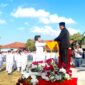 Kepala SMAN 2 Pamekasan Moh. Arifin menyerahkan bendera merah putih kepada pengibar bendera dalam rangka upacara memperingati HUT ke-81 Kemerdekaan Republik Indonesia. (LAILIYATUN NURIYAH / KLIKMADURA)