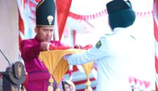 Bupati Sumenep Dr. Achmad Fauzi Wongsojudo menyerahkan sang saka merah putih kepada petugas pengibar bendera. (KLIKMADURA)
