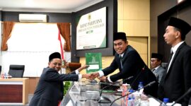 Anggota Fraksi PKB, Moh. Hasyim Asy'ari saat menyerahkan dokumen pandangan umum fraksi atas Raperda penyelenggaraan pemerintahan desa. (MOH. IQBALUL KHAVEI MZ / KLIKMADURA)