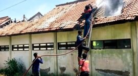 Tim pemadam kebakaran berjibaku menjinakkan api yang melalap SDN Rongtengah 5 Sampang. (ISTIMEWA)
