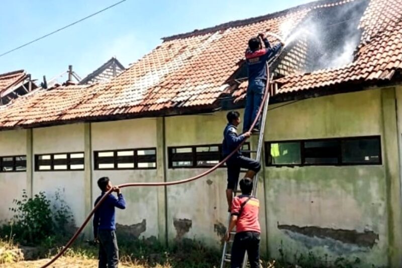 Tim pemadam kebakaran berjibaku menjinakkan api yang melalap SDN Rongtengah 5 Sampang. (ISTIMEWA)