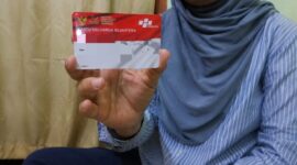 Salah satu warga menunjukkan kartu PKH. (ALI MUCHTAR / KLIKMADURA)