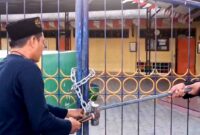Ketua PD Muhammadiyah Pamekasan Azis Ashari membuka paksa gerbang TK ABA IV Pamekasan yang disegel ahli waris tanah. (ISTIMEWA).