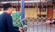 Ketua PD Muhammadiyah Pamekasan Azis Ashari membuka paksa gerbang TK ABA IV Pamekasan yang disegel ahli waris tanah. (ISTIMEWA).