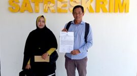Siti Nurul Aini Siska, bersama kuasa hukumnya, Zaini menunjukkan bukti laporan di depan Kantor Satreskrim Polres Pamekasan. (ISTIMEWA)