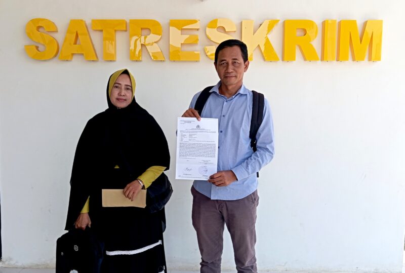 Siti Nurul Aini Siska, bersama kuasa hukumnya, Zaini menunjukkan bukti laporan di depan Kantor Satreskrim Polres Pamekasan. (ISTIMEWA)