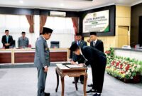 Ketua DPRD Pamekasan, Ali Masykur saat menandatangani  dokumen KUA-PPAS tahun anggaran 2027 saat sidang paripurna DPRD Pamekasan. (MOH. IQBALUL KHAVEI MZ / KLIKMADURA)