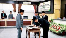 Ketua DPRD Pamekasan, Ali Masykur saat menandatangani  dokumen KUA-PPAS tahun anggaran 2027 saat sidang paripurna DPRD Pamekasan. (MOH. IQBALUL KHAVEI MZ / KLIKMADURA)