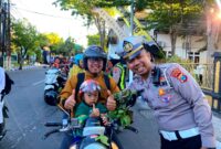 Polantas Polres Sampang foto bersama pengendara yang tertib berlalu lintas. (KLIKMADURA)