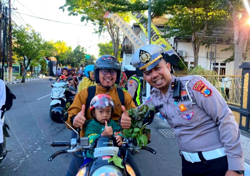 Polantas Polres Sampang foto bersama pengendara yang tertib berlalu lintas. (KLIKMADURA)