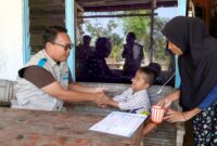 Assistant Manager Keuangan dan Umum PLN UP3 Madura, Nur Rella Catur Trisno Wahyudi menyerahkan bantuan kepada anak penderita gizi buruk. (KLIKMADURA)