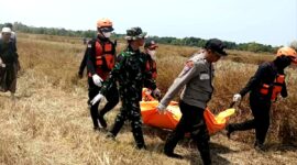 Aparat kepolisian saat mengevakuasi jenazah Buk Sida yang ditemukan di persawahan. (KLIKMADURA)