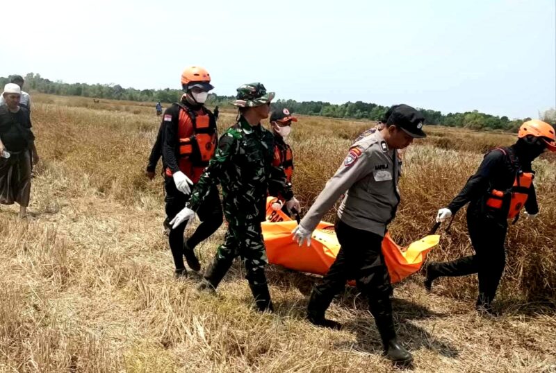 Aparat kepolisian saat mengevakuasi jenazah Buk Sida yang ditemukan di persawahan. (KLIKMADURA)
