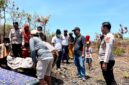 Petugas saat melakukan penanganan terhadap perempuan yang ditemukan meninggal dunia di area tanah tegal Dusun Aengnyior, Desa Lobuk, Kecamatan Bluto, Sumenep. (HUMAS POLRESTA SUMENEP FOR KLIKMADURA)