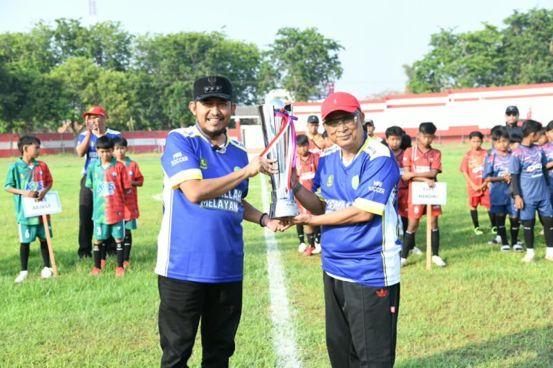 Bupati Sumenep, Achmad Fauzi Wongsojudo (kiri) bersama Kepala Dinas Pendidikan, Mohamad Iksan mengangkat trofi turnamen mini soccer U-13. (KLIKMADURA)