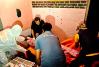 Aparat kepolisian saat mengevakuasi jenazah MR di Desa Pamolokan, Kecamatan Kota, Kabupaten Sumenep. (KLIKMADURA)
