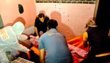 Aparat kepolisian saat mengevakuasi jenazah MR di Desa Pamolokan, Kecamatan Kota, Kabupaten Sumenep. (KLIKMADURA)