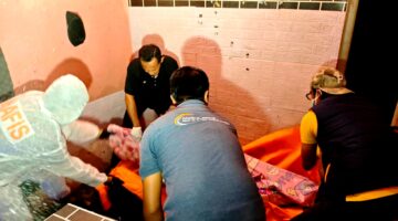 Aparat kepolisian saat mengevakuasi jenazah MR di Desa Pamolokan, Kecamatan Kota, Kabupaten Sumenep. (KLIKMADURA)