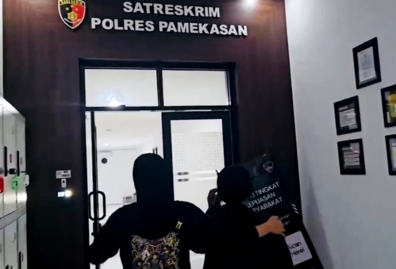Personel Satreskrim Polres Pamekasan menggiring DPO dugaan investasi bodong setelah berhasil ditangkap di Bojonegoro. (ISTIMEWA)