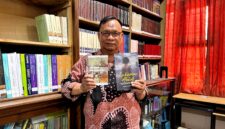 Dosen Sastra Prodi Pendidikan Bahasa Indonesia, Unira, Muhammad Tauhed Supratman memegang buku karyanya berjudul Lukamu Abadi dan buku Kumpulan Puisi Ranjang Poskolonial karya Royyan Julian di Perpustakaan Unira, Senin (12/10/2026) (LAILIYATUN NURIYAH/KLIK MADURA).