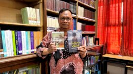 Dosen Sastra Prodi Pendidikan Bahasa Indonesia, Unira, Muhammad Tauhed Supratman memegang buku karyanya berjudul Lukamu Abadi dan buku Kumpulan Puisi Ranjang Poskolonial karya Royyan Julian di Perpustakaan Unira, Senin (12/10/2026) (LAILIYATUN NURIYAH/KLIK MADURA).