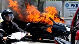 Warga berada di sekitar Mobil Xenia yang terbakar. (KLIKMADURA)