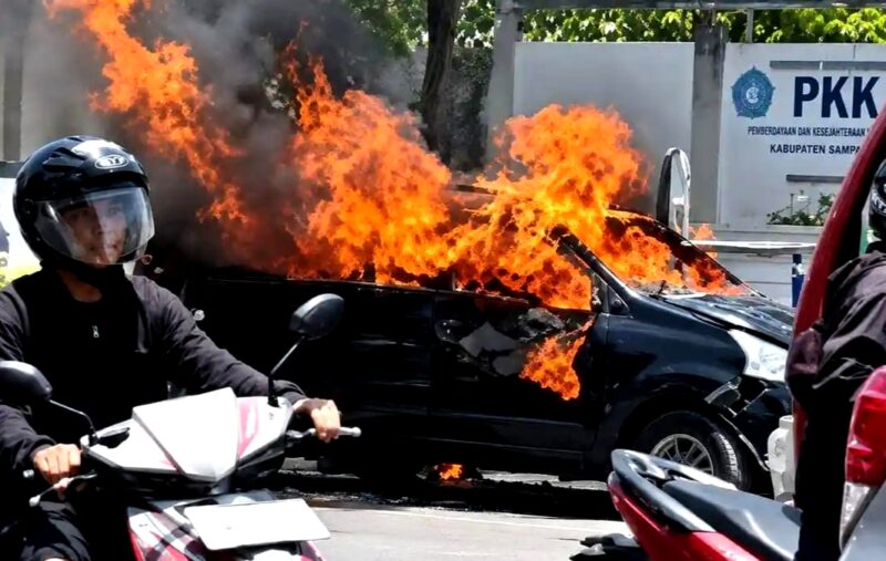Warga berada di sekitar Mobil Xenia yang terbakar. (KLIKMADURA)